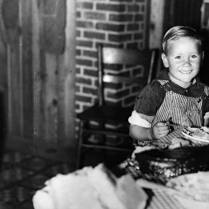 FARM BOY, 1940. Child of a former sharecropper eating at a table in southeast Missouri