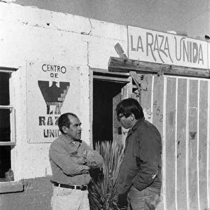 Florencio Arciniega, Jr. (right), a college student working for the Arizona State Employment Service under the federal UYA (University Year for ACTION) program, speaking with Antonio Gomez, a maintenance worker for the Chicano rights organization La Raza Unida, in the border town of Douglas, Arizona, 1972