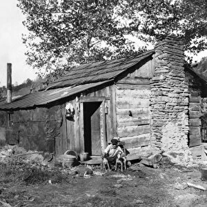HINE: LOG CABIN, 1921. A small run-down log cabin occupied by a family that has