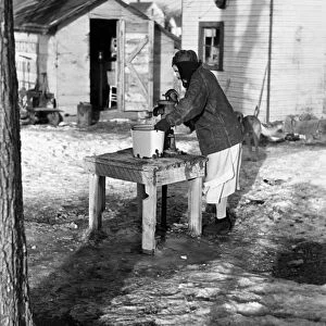 IOWA: WATER PUMP, 1936. Woman pumping water for laundry in a shanty town in Spencer, Iowa