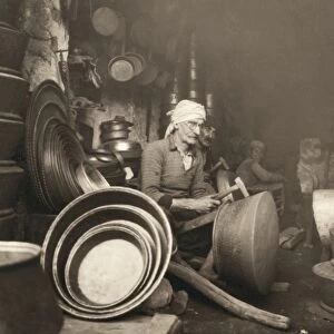 ISRAEL: METAL WORKERS, 1938. Coppersmith at Nazareth, Israel, hammering out a dist. Photograph by John D. Whiting, 1938