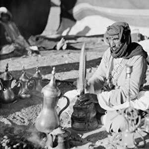 JORDAN: BEDOUIN MAN. A Bedouin man pounds coffee into grounds in Jordan. Photograph