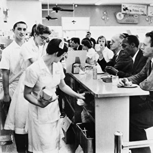 Lunch counter employees at a Peoples Drug store in Arlington, Virginia, preparing to close early while black and white customers stage a sit-in demonstration, 9 June 1960