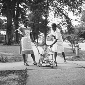 MISSISSIPPI: MAIDS, 1940. Two African American maids caring for a white child, in Port Gibson
