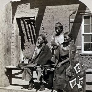 NAVAJOS, 1873. Navajo boys and woman in front of old Fort Defiance quarters, New Mexico
