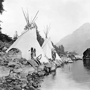 NORTHWEST INDIANS, 1922. Native Americans (probably Umatilla) stand beside tepees on the Columbia River. Photographed in 1922 by Ralph Irving Gifford