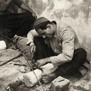 PALESTINE: METAL WORKER. A metal worker in Nazareth, Palestine, cutting teeth on a sickle