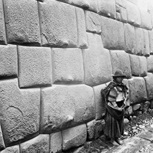 PERU: NATIVE AMERICAN, c1907. A Native American standing beside an ancient Incan