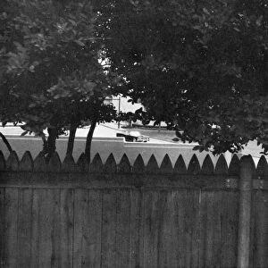 Photograph of what would have been a gunmans view of the John F. Kennedys car if he had been hidden behind the fence on the grassy knoll at the time of Kennedys assassination in Dallas, Texas, 22 November 1963. Photograph by Stephen White, 1968