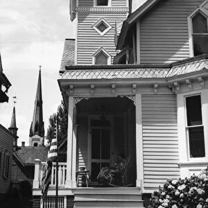 FRONT PORCH, 1938. Woman sitting on the front porch of a home on 4 July 1938, at Dover, Delaware
