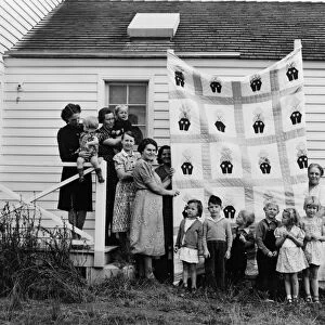 QUILT MAKERS, 1939. Members of the Helping Hand charity club, displaying a quilt