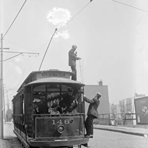 STRIKEBREAKERS, 1916. Strikebreakers on top of a broken streetcar during a streetcar