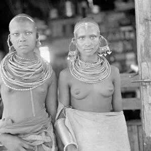 TANGANYIKAN GIRLS, 1936. Girls wearing large earrings and numerous neck rings