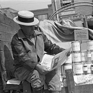 TEXAS: HONEY VENDOR, 1939. Honey peddler reading a newspaper in a farmers market in San Antonio