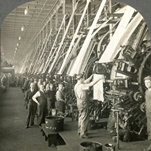 TEXTILE MILL, c1915. A foreman inspects a newly-imprinted piece of cotton cloth at a textile mill