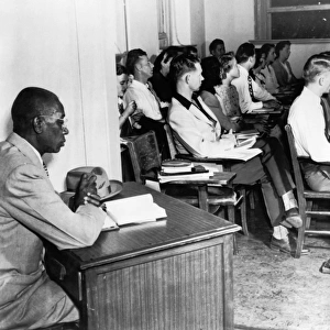 White students in class at the University of Oklahoma, while G. W. McLaurin, an African American student, is seated in the anteroom. Photograph, 1948