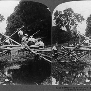 WORLD WAR I: BRIDGE. Troops building a temporary bridge for the transport of motor