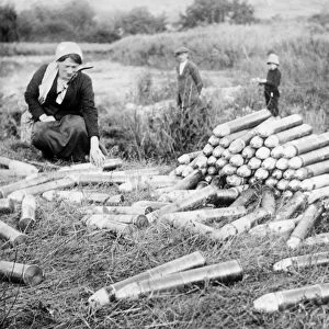 WWI: AMMUNITION, 1914. Civilians looking at artillery shells abandoned by the German