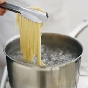 Adding noodles to saucepan of boiling water