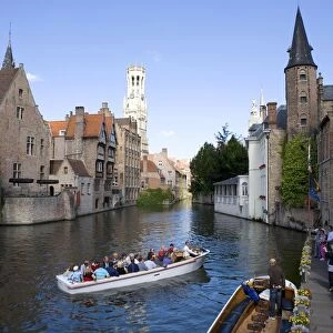 Belgium, Brugge, passengers in boat on canal approaching waterfront