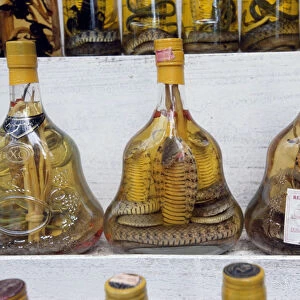 Three bottles of Vietnamese snake rice wine at Cu Chi market, close-up