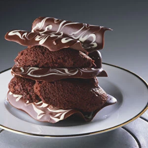 Chocolate dessert on a gold-rimmed plate, stacked chocolate curls filled with mousse, close up