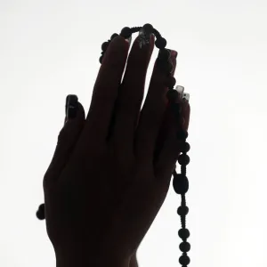 Christian woman praying the Rosary. Close-up. Vietnam