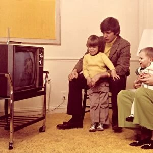 Family watching TV in 1970s home