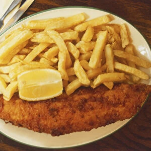 Fish and chips with a wedge of lemon on a plate
