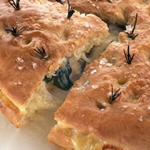 Focaccia farcita, filled with cheese and basil leaves and topped with rosemary and sea salt