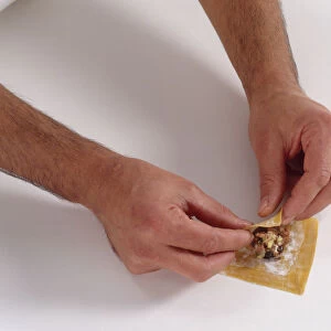Folding wonton wrapper around filling ingredients