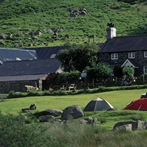 Great Britain, Wales, Snowdonia, Caernarfonshire, Ogwen Valley, farmhouse with tents pitched in a campsite in foreground