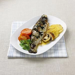Grilled trout with orange and mustard glaze, served with onions, mushrooms, tomatoes