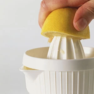 Half a lemon being squeezed over a lemon juicer
