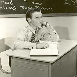 Historic image of boy daydreaming in class, black and white