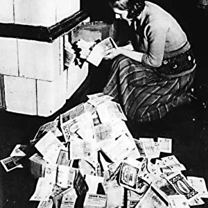 Hyperinflation in Germany post World War I: Woman uses bank notes to fuel a stove