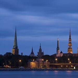 Latvia, Riga, Western Daugava River and spires of old town, illuminated at night