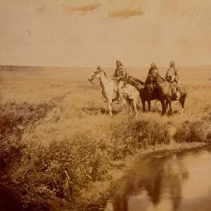 Three Piegan men on horseback in open grassland near pond, c1900. Photograph by Edward Curtis