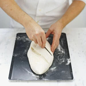 Slashing the upper surface of a bread dough