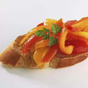 Slice of baguette bread with red and yellow papper topping