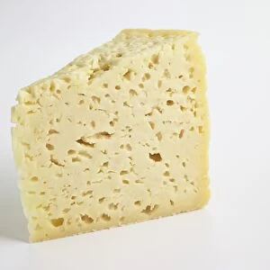 Slice of Italian Pannerone cows milk cheese showing holes