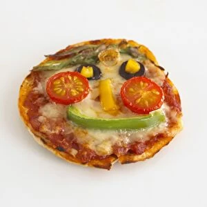 Smiley face cheese pizza on pitta bread with peppers, tomatoes and mushrooms