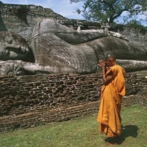 Sri Lanka, Ancient City of Polonnaruwa, Reclining Buddha statue and praying monk