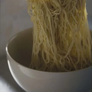 Steaming spaghetti above bowl