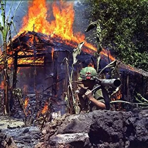 My Tho, Vietnam. A Burning Vietcong Base Camp. In the foreground is Private First