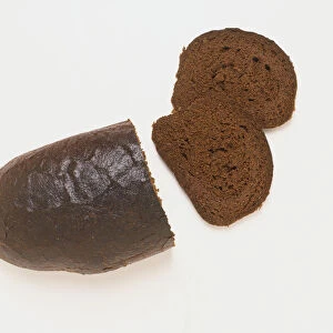 Ukranian loaf of black bread with two slices cut from the end, view from above