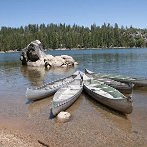 USA, California, Sierra, Pinecrest Lake, canoes and rocks in lake