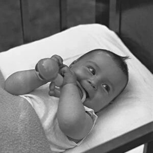 Baby (3-6 months) lying in crib, (B&W), elevated view
