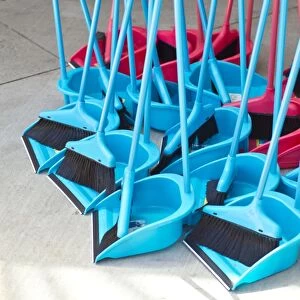 Blue and red brooms with shovels