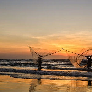 Two Fishermen fishing on the beach at dawn in Vietnam